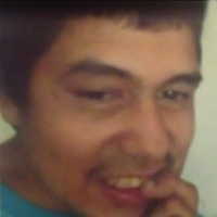 Photo of Anthony Corona. He is a teenager with olive skin and black hair. He is smiling and has a finger to his mouth.