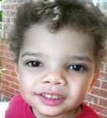 Photo of Mason Bryan, a toddler boy with curly brown hair, tan skin, and dark-brown eyes. He is smiling slightly.